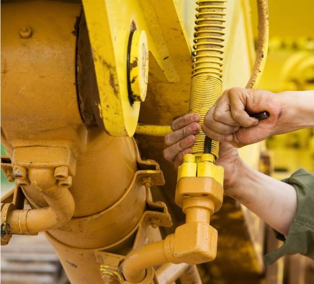 heavy diesel mechanic fixing yellow earthmoving machinery